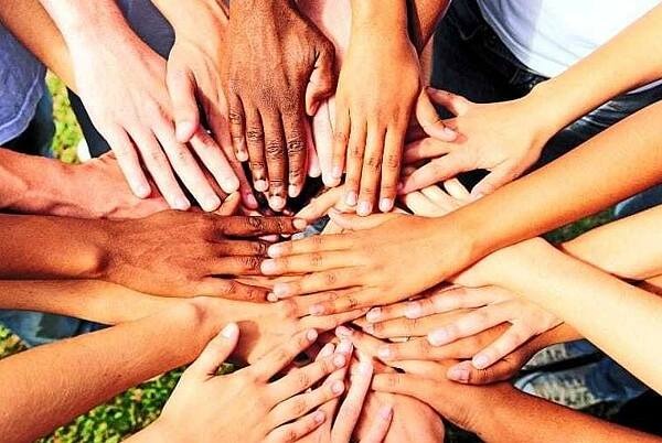 Viele Hände zu einem Kreis übereinander- und zusammengelegt