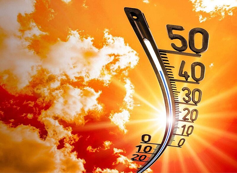 Ein Thermometer steigt vor einem orangenen Himmel mit Wolken in der Hitze auf über 40 Grad Celsius