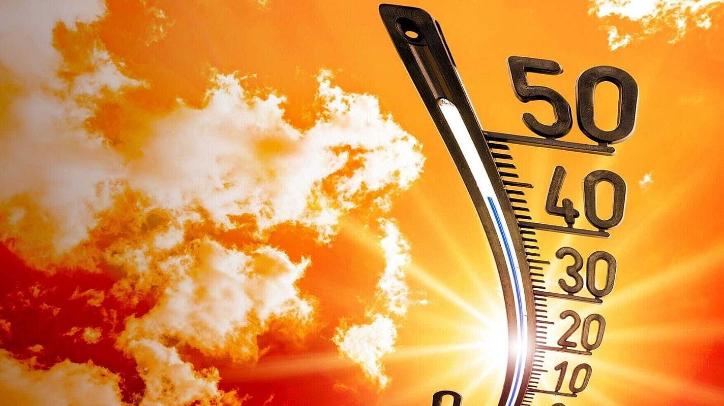 Ein Thermometer steigt vor einem orangenen Himmel mit Wolken in der Hitze auf über 40 Grad Celsius