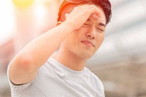 Ein Mann mit schmerzverzerrtem Gesicht hält sich den Kopf 